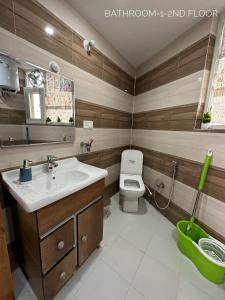 een badkamer met een wastafel en een toilet bij Dhauladhar Homes in Dharamshala