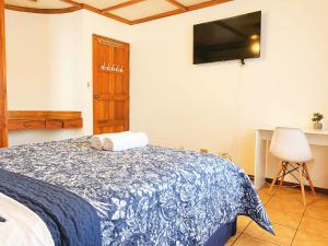 a bedroom with a bed and a tv on the wall at CASA 8 Bed&Breakfast in San José