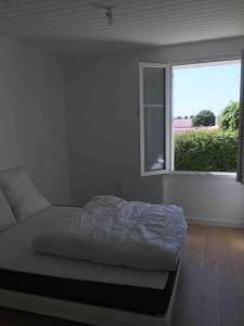 um quarto branco com uma cama e uma janela em Gîte rénové 6 pers, grand jardin, très calme em Saint-Michel-en-lʼHerm