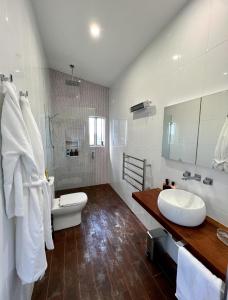 a bathroom with a sink and a toilet and a tub at The View @ Ulandi in Lowther