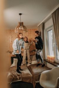 three people standing on a bed in a room at FARIE in Faryny