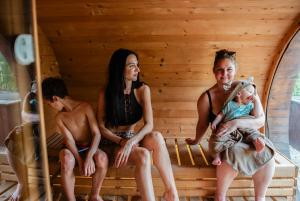 Eine Gruppe von Menschen sitzt mit einem Baby in einer Sauna. in der Unterkunft FARIE Mazury Dom na wyłączność dla 20 osób z Basenem, Sauną i Jacuzzi in Faryny + 62 Fotos