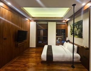 Kaomai Lanna Resort في San Pa Tong: غرفة نوم بسرير وتلفزيون بشاشة مسطحة