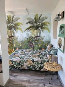 a bedroom with a bed with palm trees on the wall at Loft 40m2 avec terrasse pilotis in Fréjus