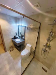 uma casa de banho com um WC, um lavatório e um chuveiro em Wave View Hotel em Seeb
