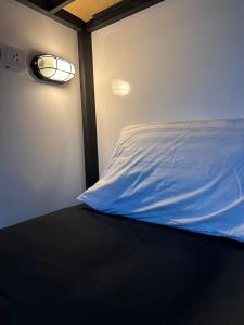una camera da letto con un letto con una luce sul muro di Rainbow hostel a Chiang Mai