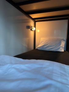 una camera da letto con un letto bianco e una luce sopra di Rainbow hostel a Chiang Mai
