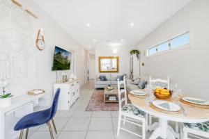 eine Küche und ein Wohnzimmer mit einem Tisch und Stühlen in der Unterkunft On Esplanade own flat & Pool, Manly cafe precinct in Brisbane