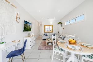 布里斯班On Esplanade own flat & Pool, Manly cafe precinct的配有桌椅的厨房和客厅