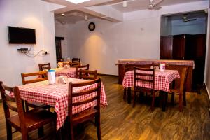 un ristorante con tavoli e sedie con tovaglia rossa e bianca di HOTEL AQUA BREEZE a Port Blair