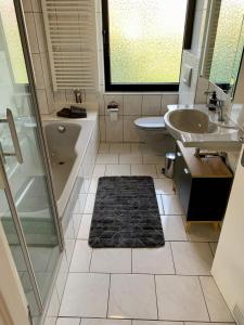 uma casa de banho com uma banheira, um lavatório e um WC. em Haus Nummer Vier em Neunkirchen