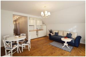 uma sala de estar com um sofá e uma mesa em Smėlynas Neringa Apartments em Neringa