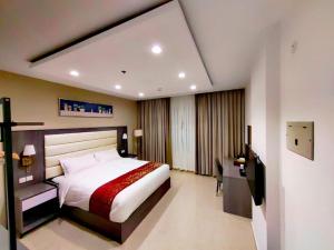 a bedroom with a bed and a desk and a television at Wave View Hotel in Seeb