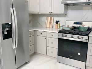 uma cozinha branca com um fogão e um frigorífico em 靠近舊金山國際機場的民宿 em Daly City