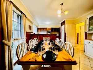 un tavolo in legno con sedie e una sala da pranzo di Cozy 5BR Home with Pool table and King bed a Wantirna South