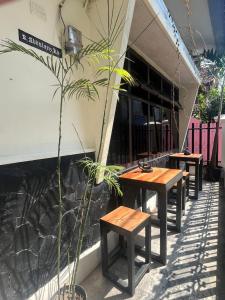 a row of tables and benches next to a building at Good Feeling Hostel in Banyuwangi