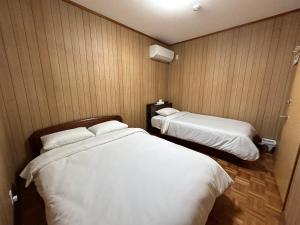a hotel room with two beds in it at KIX House Waraku III 和楽三号館 in Izumi-Sano