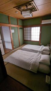 un grande letto in una stanza con pareti verdi di KIX House Waraku III 和楽三号館 a Izumisano