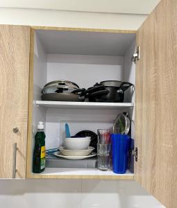 a cabinet filled with dishes and utensils at Confortable habitación con baño privado in Bogotá