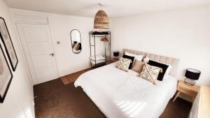 1 dormitorio con 1 cama con sábanas y almohadas blancas en 2 Bed Cosy Aylesbury House with Parking, en Buckinghamshire