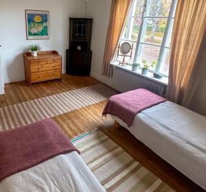 a bedroom with two beds and a window at Fridhem in Stjärnsund