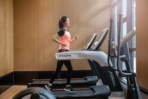 a woman running on a treadmill in a gym at Wanda Jin Pingxiang in Pingxiang