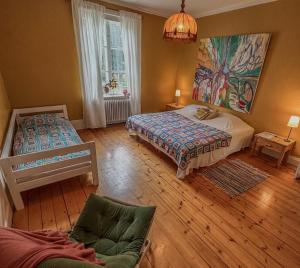 a bedroom with two beds and a couch in it at Fridhem in Stjärnsund