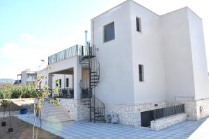a white house with a spiral staircase on it at Polles Εlies Cozy Αpartment in Egina