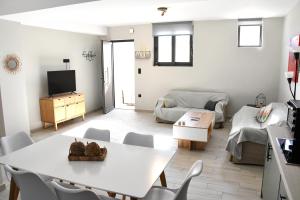 a living room with a white table and chairs at Polles Εlies Cozy Αpartment in Aegina Town