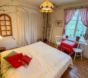 a bedroom with a large white bed with red pillows at Fridhem in Stjärnsund