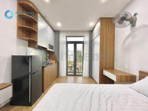 a bedroom with a bed and a kitchen with a refrigerator at Moon Apartment in Ho Chi Minh City