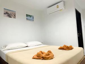 een wit bed met twee bruine handdoeken erop bij Bang sit Guest House in Phi Phi Don