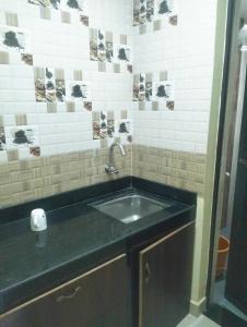 a sink in a bathroom with a black counter at Anika homes in Canacona