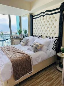 een slaapkamer met een groot bed en een groot raam bij Azure Urban Resort - St Tropez Tower Staycation Unit with a European Touch in Manilla