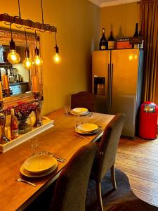een houten tafel met stoelen en een koelkast in een keuken bij Deluxe Altbaucharme in zentraler Lage in Kiel