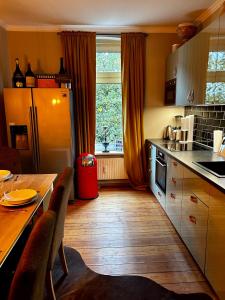 a kitchen with a wooden table and a kitchen with a window at Deluxe Altbaucharme in zentraler Lage in Kiel