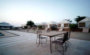 einen Tisch und Stühle auf einer Terrasse mit Zelten in der Unterkunft Ekanta Resort in Sām
