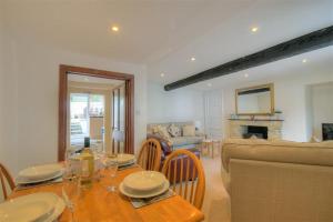 een woonkamer met een tafel en een bank bij Foxley Cottage in Charmouth