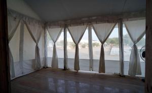 Zimmer mit einem großen Fenster und weißen Vorhängen in der Unterkunft Ekanta Resort in Sām