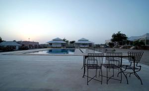 einer Gruppe von Stühlen und einem Tisch vor einem Pool in der Unterkunft Ekanta Resort in Sām