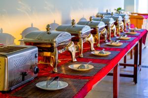 a row of tables with plates and a toaster at SPARV Aulakhs Resort in Mandrem