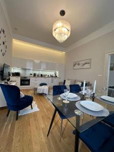 - un salon avec une table à manger et des chaises bleues dans l'établissement The Pearl, à Budapest