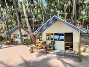 Cabaña pequeña en la playa con palmeras en Cola Beach Sunset Bay en Cola