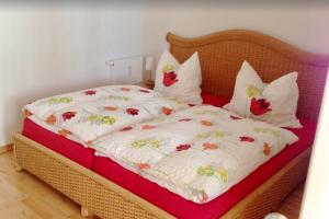 uma cama com um cobertor branco com flores em Haus Sonnenhaken Wohnung 1 em Norderney