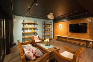 a living room with a table and chairs and a tv at Vestique hostel in Chiang Mai