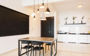 a kitchen with a wooden table and chairs at Boulevard Service Apartment KL by Airhost in Kuala Lumpur