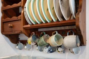 a bunch of cups and plates hanging on a wall at Sira Stonehouse l in Volímai