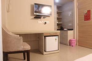 a living room with a tv and a table and a chair at Sridham Holiday Vrindavan in Vrindāvan