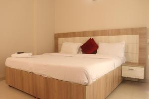 a bedroom with a large bed with a wooden headboard at Sridham Holiday Vrindavan in Vrindāvan