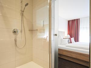 uma casa de banho com um chuveiro e uma cama em Landhotel Mohren em Schwarzenbach